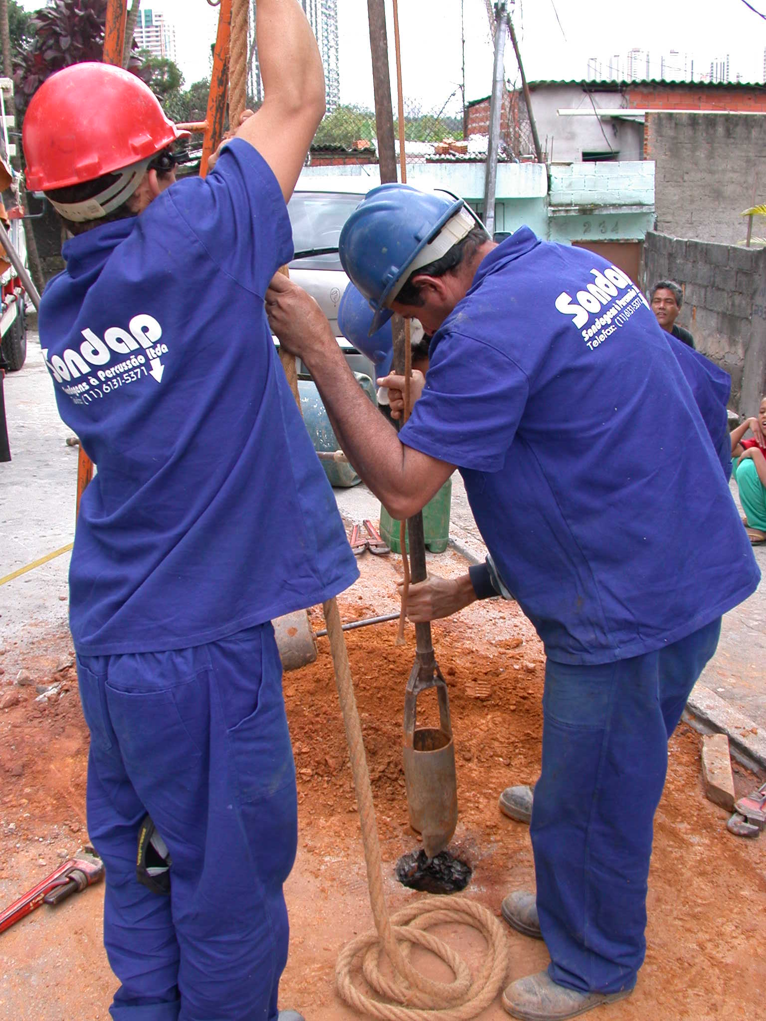 Profissionais operando equipamento em sondagem SPT